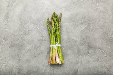 Beton arka planda bir sürü yeşil kuşkonmaz. Üst görünüm