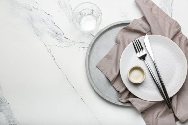Beyaz zemin üzerinde çatal bıçak, cam ve peçete dolu boş tabak ve metin için boşluk