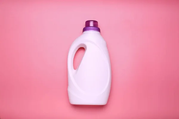 powder, washing gel, conditioner bottle without label on pink background top view copy spece