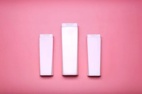 shampoo bottles on pink background.Minimalism, place for text. Top view .mockup