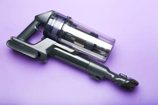 Vacuum cleaner on violet  background. Top view. Cleaning concept.