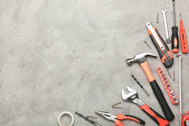 Gri arka planda çeşitli inşaat aletleri. Ev onarımı için aletler. İnşaat alanında çalışıyorum. Üst Manzara. Metin için boşluk
