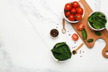 Tahta kesme tahtasındaki biberli ıspanaklı domatesler. Beyaz arkaplan, üst görünüm