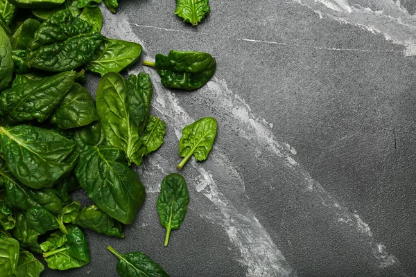 Organic food concept with spinach leaves on black background top view