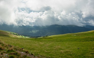 Fırtınalı bulutlar ve alçak dağlar ve ParangMoundlar 'ın dağlık çayırları Carpathia' yı kaplıyor. İlkbahar havası.