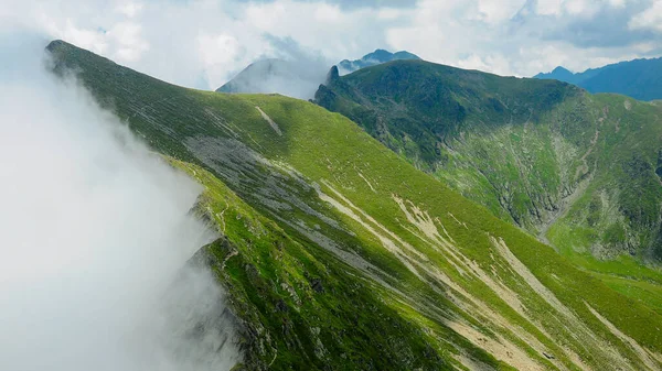 狂暴的云雾笼罩着法加拉斯山脉陡峭的山峰 高山草场是明亮的绿色 罗马尼亚喀尔巴阡山 — 图库照片