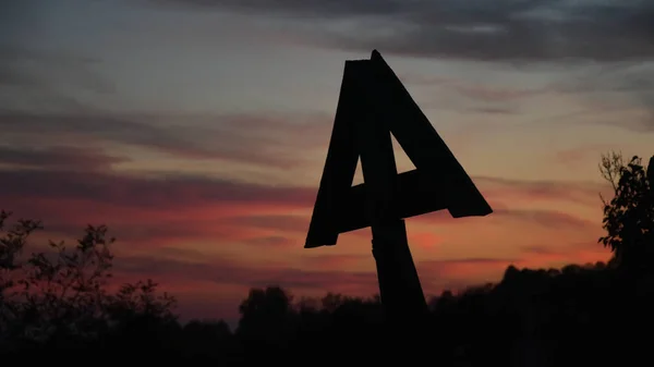Gün batımında eski, ahşap bir Hıristiyan haçı silueti..