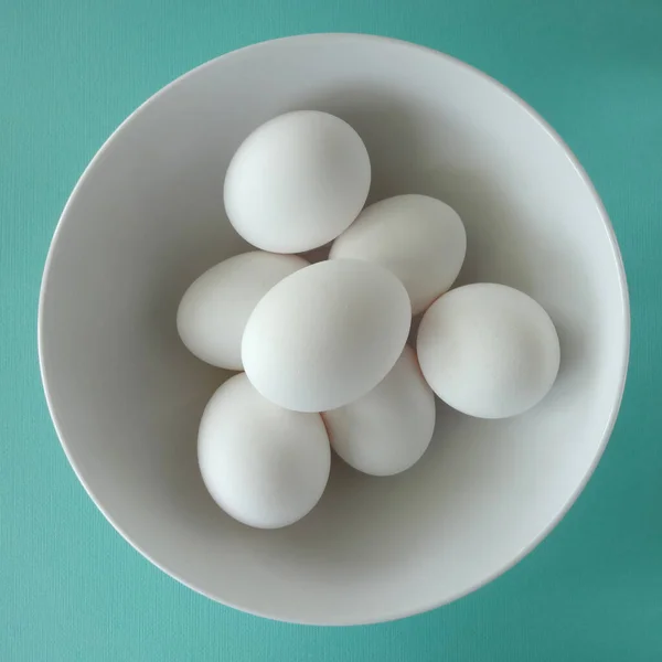 Seven White Eggs White Bowl Teal Background — Stockfoto