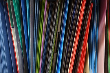 Colorful Pocket Folders Stored Vertically on a Shelf
