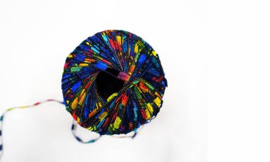 Isolated Spool of Multi-Colored Thread Unraveling Against a White Background