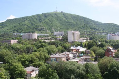 Pyatigorsk şehri. Yeşil bitki örtüsüyle kaplı Mashuk Dağı manzarası. Dağın tepesinde bir TV yayın kulesi var..