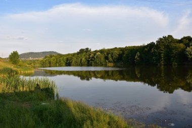 Gölün temiz ve huzurlu yüzeyi zengin ve yeşil doğayla çevrili. Arka planda Avala kulesi