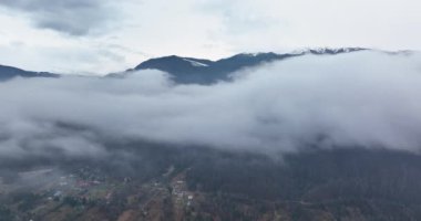 Bulutların üstünde uçarak zirvedeki karla dağları keşfediyorlar..