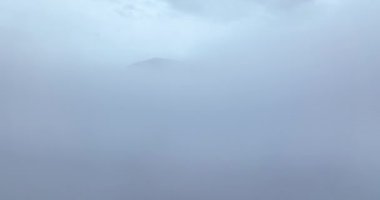 İnsansız hava aracı gölün üzerindeki bulutlarda uçarak dağı açığa çıkarıyor. Kış manzarası