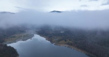 Geriye doğru uçmak arka plandaki dağı ortaya çıkarır. Sisli sonbahar sabahı