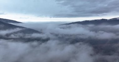 Bulutların üstünde uçuyor, sis ve dağ altında gölü açığa çıkarıyor..