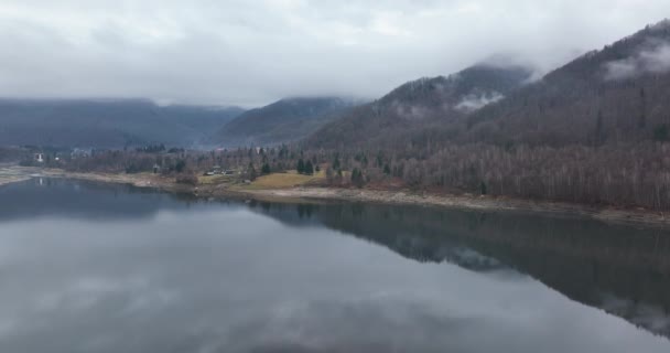 Aerial drone shot of Misty Autumn Forest and Lake in Europe. Volar sobre el agua — Vídeos de Stock