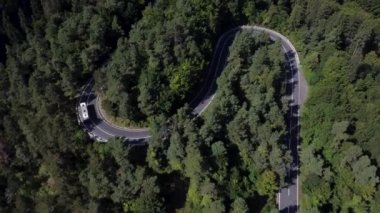 Bird eve view of a card driving on a curvy winding beautiful road 