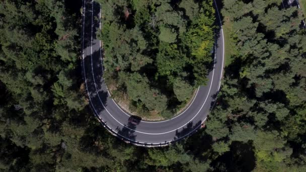 Aerial top-down view footage of a high mountain road. Cars on a curvy road — Stockvideo
