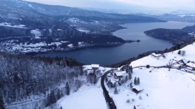 Beautiful Aerial Drone shot on a Winter Sunny day with Snow close to the lake