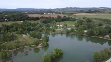 Güzel, küçük bir göl. Güzel, güneşli bir günde yol ve ormanla çevrili. 