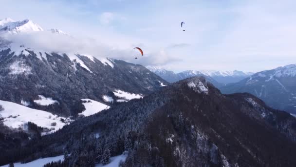 驚くべき高角度トップドローンビュー。スキー場の冬の上のスキーパラグライダー — ストック動画