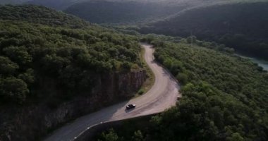 Sonbahar yolundaki arabalı gökyüzü manzarası. Güneşli bir günde bir kır yolunun havadan görünüşü. Peter Lynch