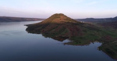 Kayalık kırmızı zeminli ve arka planında dağlar olan Salagou Gölü. Yüksek Kalite 4K Phantom 4 PRO Çekimi Haziran 2020 'de Güney Fransa' da. Lac du Salagou