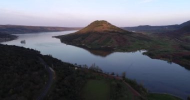 Kayalık kırmızı zeminli ve arka planında dağlar olan Salagou Gölü. Yüksek Kalite 4K Phantom 4 PRO Çekimi Haziran 2020 'de Güney Fransa' da. Lac du Salagou