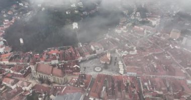 Brasov şehri yoğun sis altında. Hava görüntüsü. Açığa vur. Drone geliyor. Yüksek kaliteli DJI Mavic 34k 5.1 K görüntü Kasım 2021. Güçlendirilmiş Ortaçağ Kalesi. Konsey Eski Meydanı
