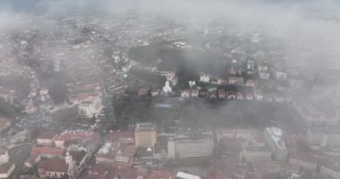 Bulutların ve sislerin arasında uçan sinematik hava Brasovlar 'ın popüler beyaz kilisesini ortaya çıkarıyor. Yüksek kaliteli DJI Mavic 34k 5.1 K görüntü Kasım 2021. Güçlendirilmiş Ortaçağ Kalesi. Konsey Eski Meydanı