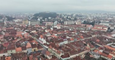 Sisli bir sabahta Brasov şehrindeki yapısal binaların yoğun manzarası. Yüksek kaliteli DJI Mavic 34k 5.1 K görüntü Kasım 2021. Güçlendirilmiş Ortaçağ Kalesi. Konsey Eski Meydanı