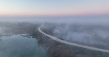 Sisli orman yolu, yağmurlu sisli gündoğumunda gizemli sonbahar manzarası. Ağustos 2021 'de Romanya' da çekilen en kaliteli 4K DJI Mavin 35.1 km görüntü