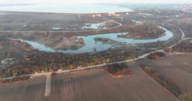 Güzel bir nehrin, bulutların ve karanın havadan görünüşü. Sonbahar gündoğumu senaryosu. Ağustos 2021 'de Romanya' da çekilen en kaliteli 4K DJI Mavin 35.1 km görüntü