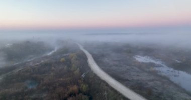 Güzel doğa videosu. Sis, bulut, gündoğumu ve yol insansız hava aracı. Ağustos 2021 'de Romanya' da çekilen en kaliteli 4K DJI Mavin 35.1 km görüntü