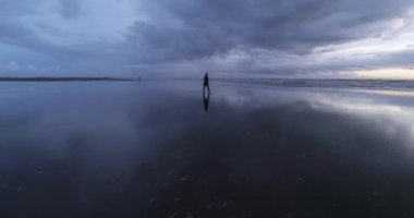 Happy carefree young girl silhouette walking on the dreamy beach. DJI Phantom 4 PRO footage. Beach sunset reflection on the ground. September 2020 at L epiguette, South of France 