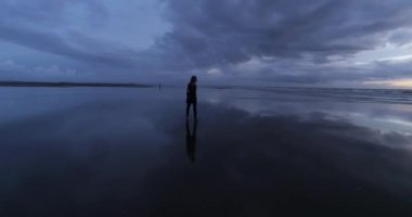 Cinematic aerial drone following attractive young women at sunset on the beach. DJI Phantom 4 PRO footage. Beach sunset reflection on the ground. September 2020 at L epiguette, South of France 