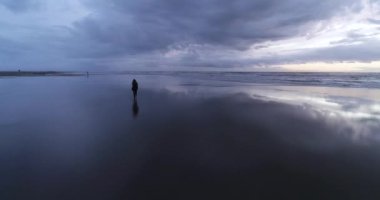 Happy healthy romantic woman shilouette circling around on the beach at sunset. DJI Phantom 4 PRO footage. Beach sunset reflection on the ground. September 2020 at L epiguette, South of France 