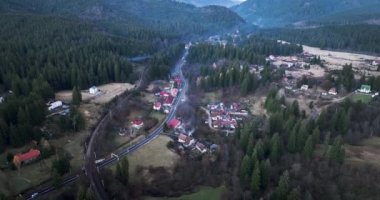 Gree kırsalındaki küçük tarihi Romen polder çiftliği köyü. Arabalar ve kamyonlar geçiyor. Ocak 2022 'de Romanya' nın Brasov kentinde çekilen yüksek kaliteli DJI Maviç 34k 5,1 k sinematik görüntü