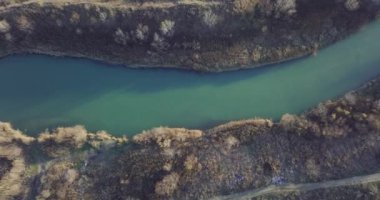 Hava görüntüleri, küçük bir göl, nehir ağzı. Güneşli bir gün. Ocak 2022 'de Romanya' nın Bragadiru kentinde çekilen yüksek kaliteli 4k Hava Sinema Dronu DJI MAVIC 35,1 k görüntü