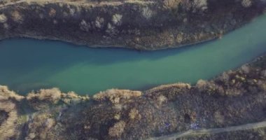 Hava görüntüleri, küçük bir göl, nehir ağzı. Güneşli bir gün. Ocak 2022 'de Romanya' nın Bragadiru kentinde çekilen yüksek kaliteli 4k Hava Sinema Dronu DJI MAVIC 35,1 k görüntü