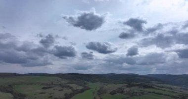 Cinematic breathtaking aerial flying on the side revealing the white clouds in the sky. High-quality 5.1k DJI Mavic 3 4k footage shoot in May 2022 in South Romania