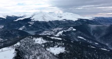 Havadan aşağıya sinematik kış karla kaplı kır yolu ve kazmalar. Ocak 2022 'de Romanya' da güneşli bir günde yüksek kaliteli DJI Maviç 35,1k ve 4k 'lık görüntüler çekildi.