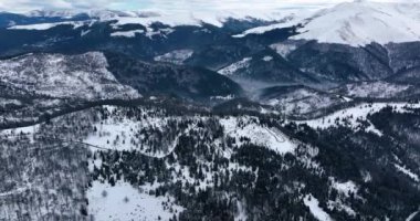 Havadan aşağıya sinematik kış karla kaplı kır yolu ve kazmalar. Ocak 2022 'de Romanya' da güneşli bir günde yüksek kaliteli DJI Maviç 35,1k ve 4k 'lık görüntüler çekildi.