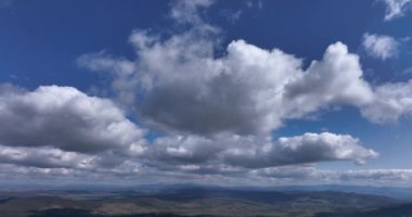 Mavi gökyüzü beyaz bulutlar. Kabarık beyaz bulutlar. Gökyüzünde kümülüs bulutları. Yüksek kaliteli 5.1k DJI Maviç Mayıs 2022 'de Güney Romanya' da 34k 'lık bir çekim