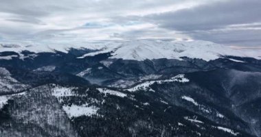 Uçan bir dron tarafından çekilen karlı dağ zirvelerindeki güzel manzara. Ocak 2022 'de Romanya' da güneşli bir günde yüksek kaliteli DJI Maviç 35,1k ve 4k 'lık görüntüler çekildi.
