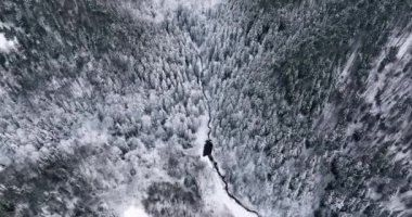 Kıvrımlı bir yolun kuş bakışı görüntüsü. Romanya 'nın dolambaçlı yolu karla kaplı. Ocak 2022 'de Romanya' da güneşli bir günde yüksek kaliteli DJI Maviç 35,1k ve 4k 'lık görüntüler çekildi.