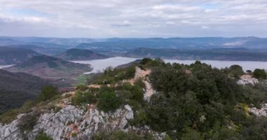 Aerial panorama of Lac du Slagou in the early morning in a windy spring. High-quality DJI Mavic 3 5.1k and 4k footage were made in January 2022 in Lac du Salagou South of France on a cloudy cold day.