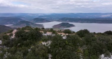 Aerial panorama of Lac du Slagou in the early morning in a windy spring. High-quality DJI Mavic 3 5.1k and 4k footage were made in January 2022 in Lac du Salagou South of France on a cloudy cold day.