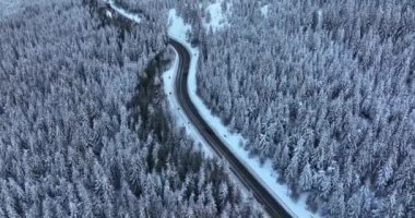 Drone flying over the narrow winding road. Middle of the snow-covered white mountain. High-quality DJI Mavic 3 5.1k and 4k footage in January 2022 in Borsa, Romania a town in eastern Maramures County